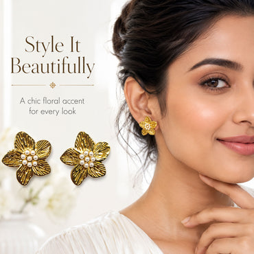 Close-up view of gold floral earrings with pearl centerpiece