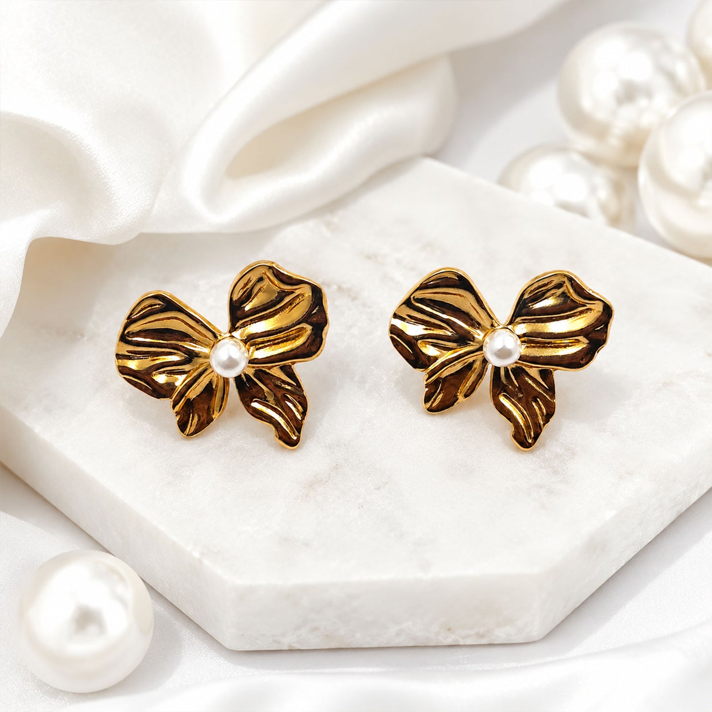 Gold bow stud earrings styled as elegant fashion jewellery