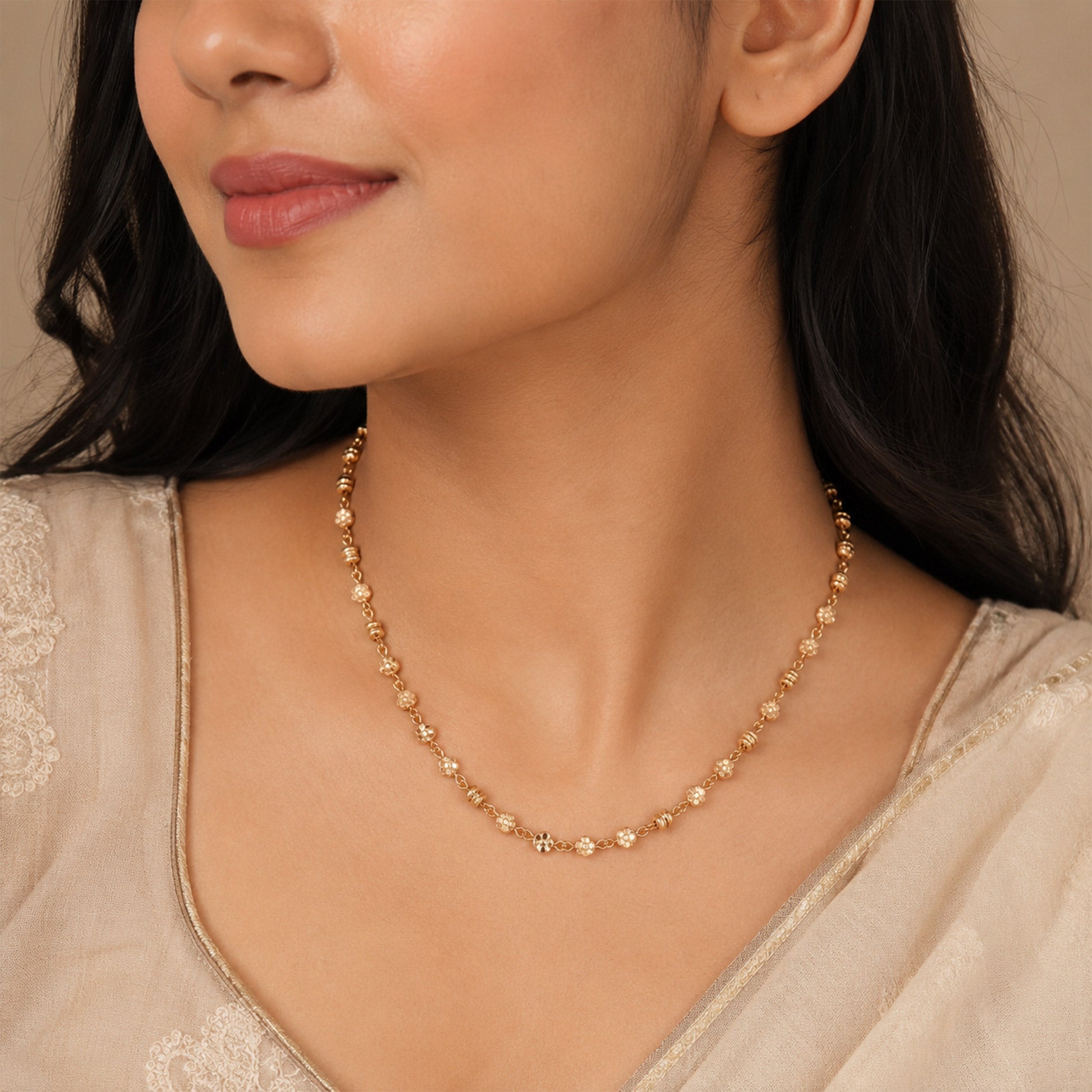 Close-up view of rose gold necklace with small flower links