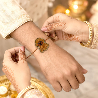 Close-up view of orange beaded puppy rakhi for brother