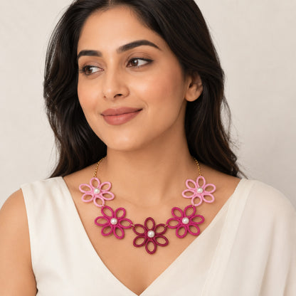 Close-up view of pink flower necklace with pearl-style centres