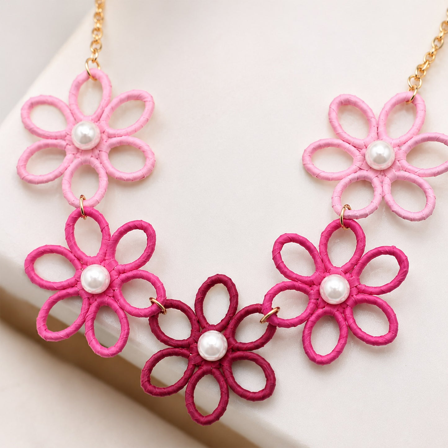 Gold plated necklace with five pink thread-wrapped flowers