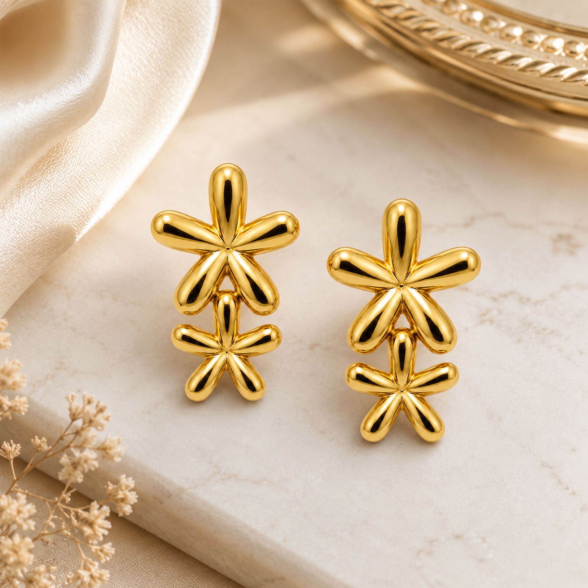 Detailed view of layered gold double flower drop earrings