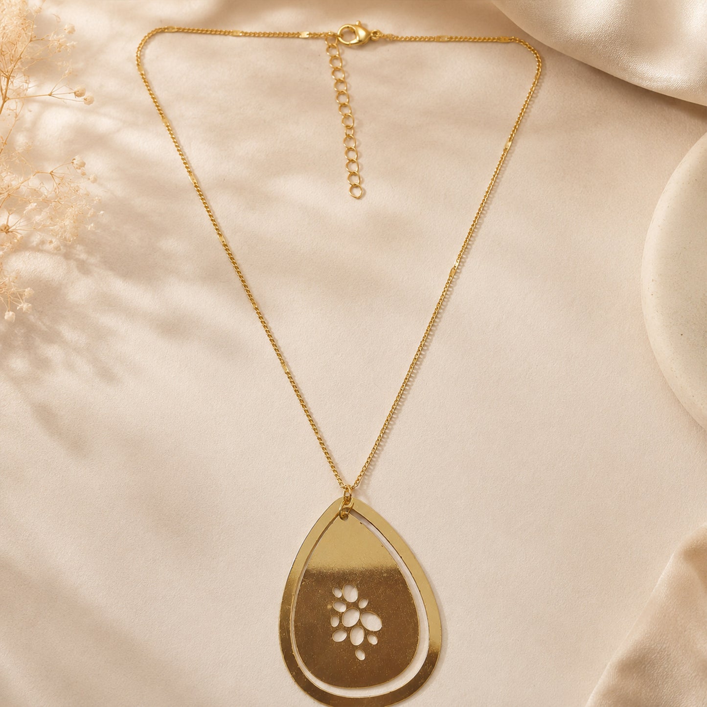Detailed view of floral cutwork gold pendant necklace