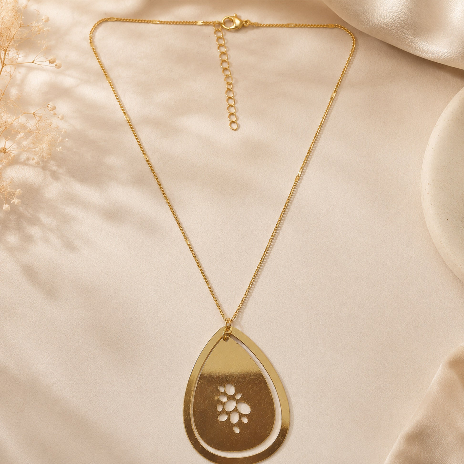 Detailed view of floral cutwork gold pendant necklace