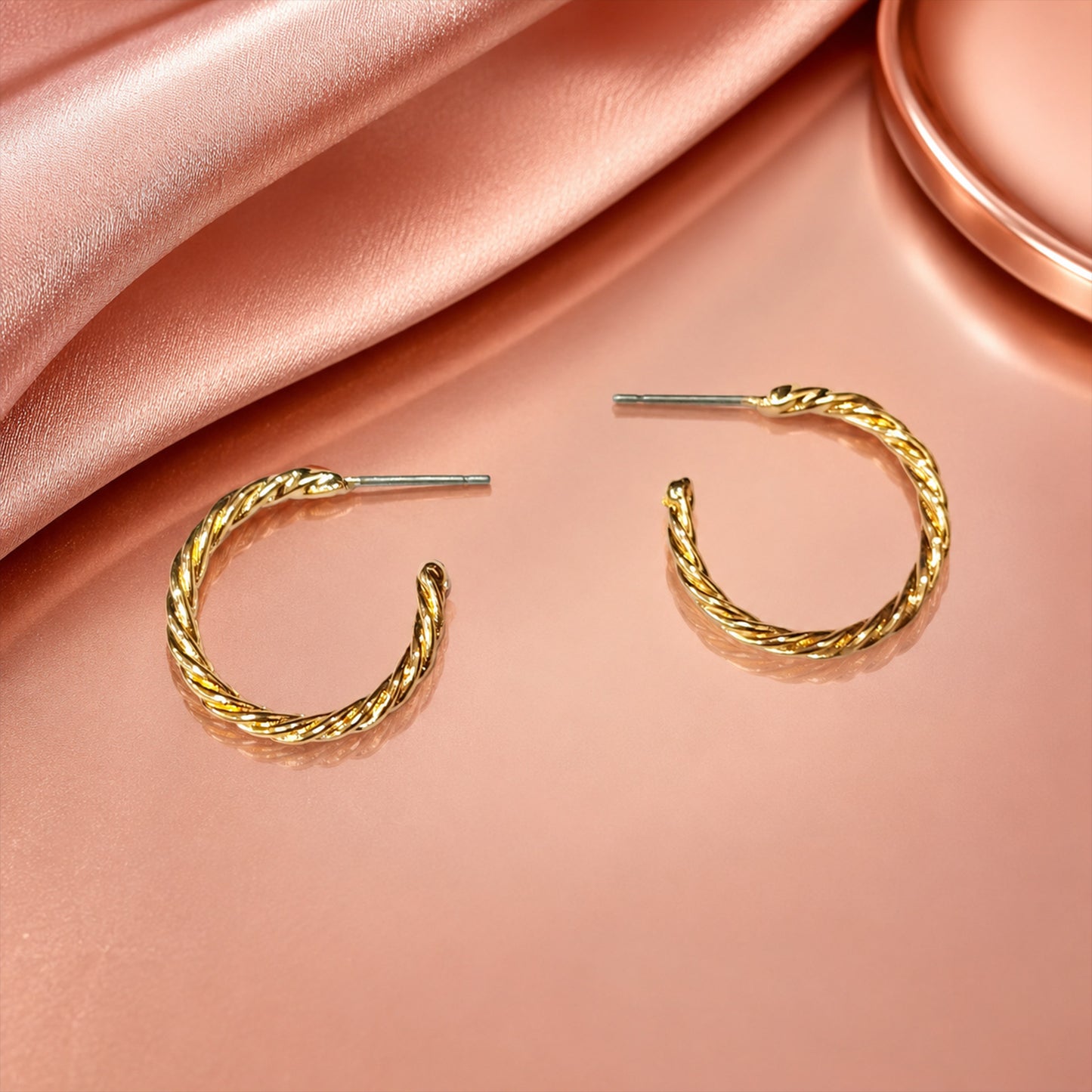 Detailed view of polished gold twisted rope hoop earrings