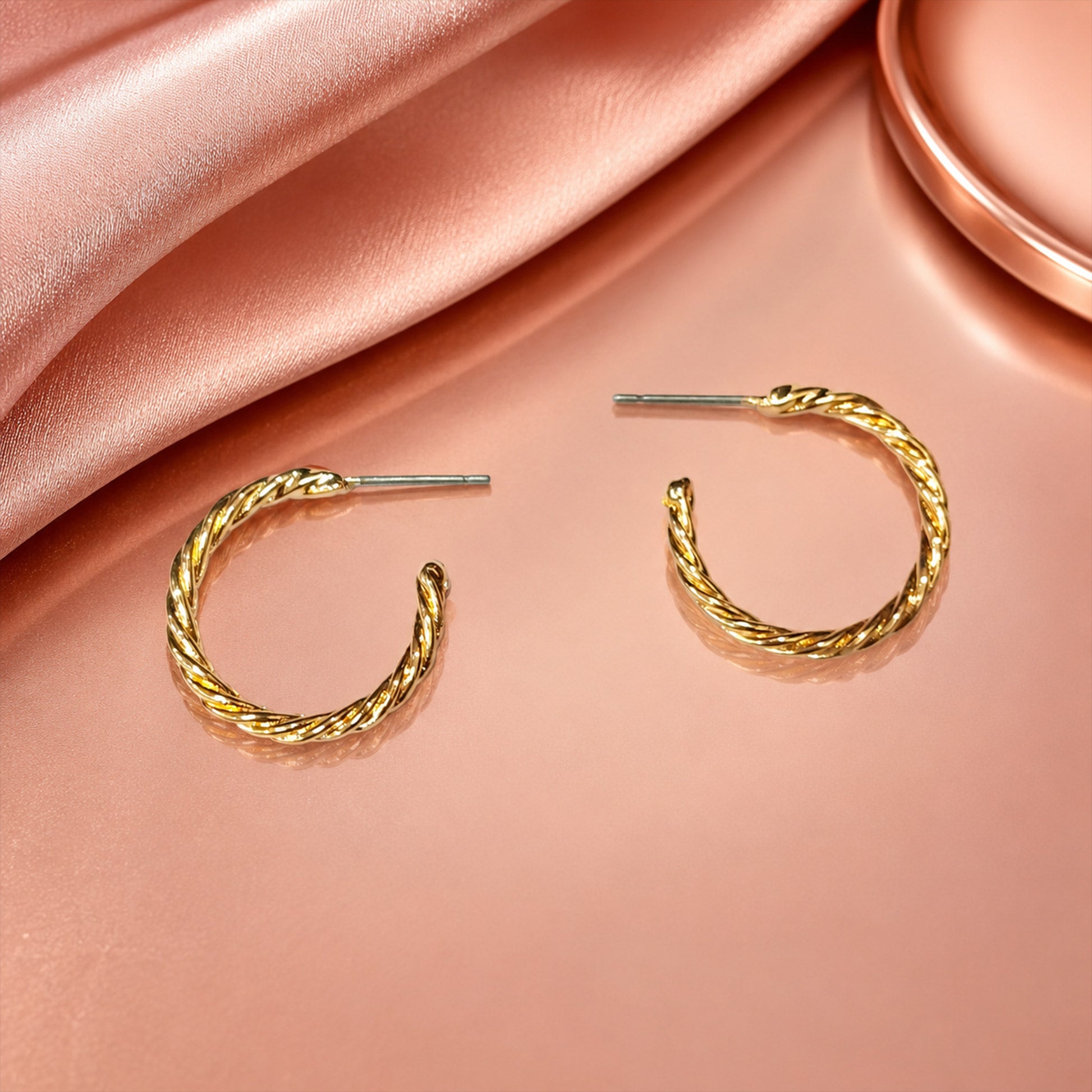 Detailed view of polished gold twisted rope hoop earrings