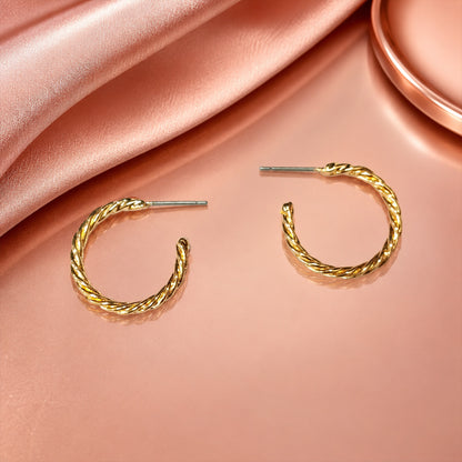 Detailed view of polished gold twisted rope hoop earrings
