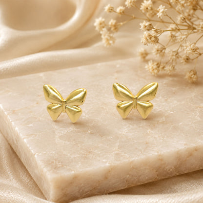 Detailed view of smooth gold butterfly stud earrings