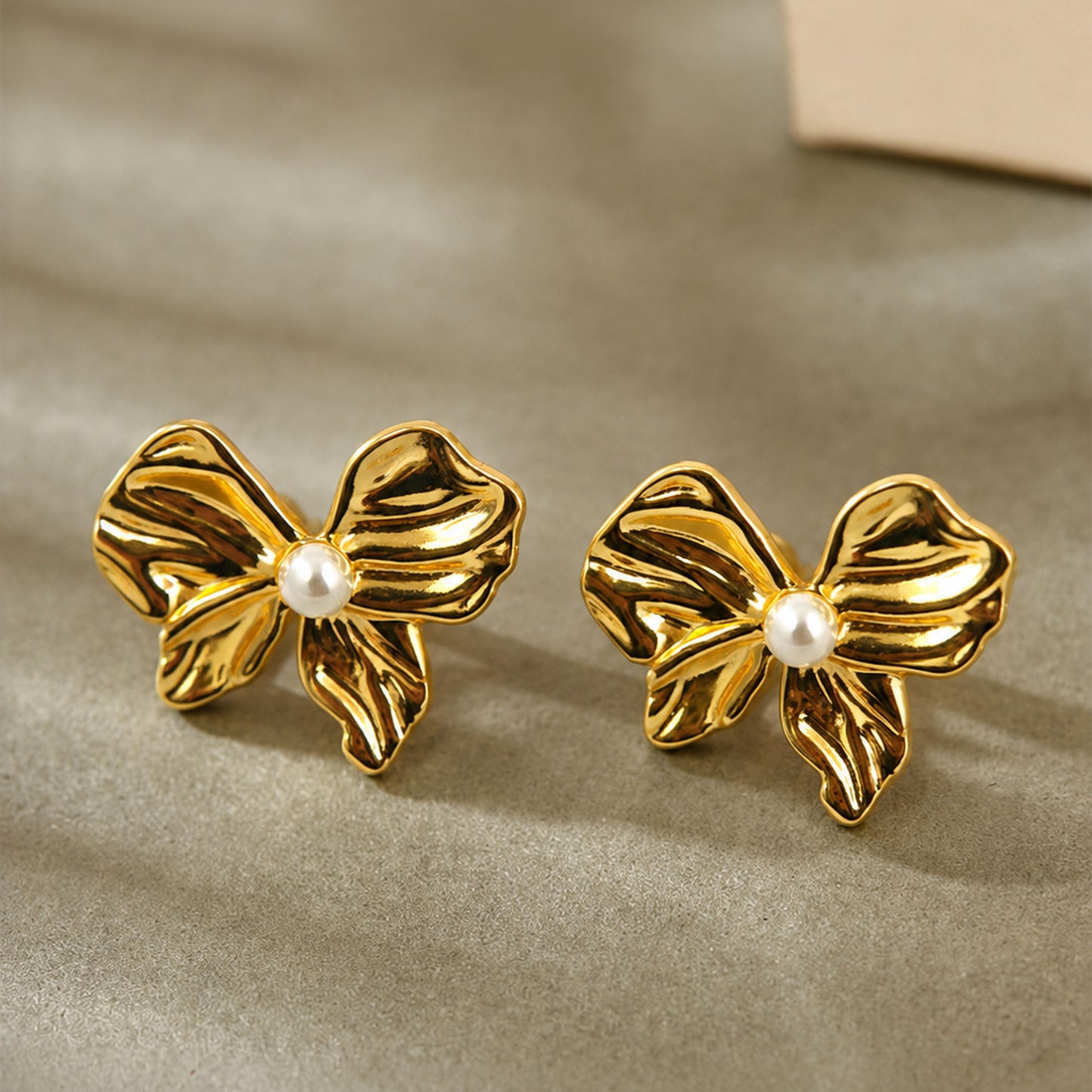 Gold plated bow stud earrings with textured detailing