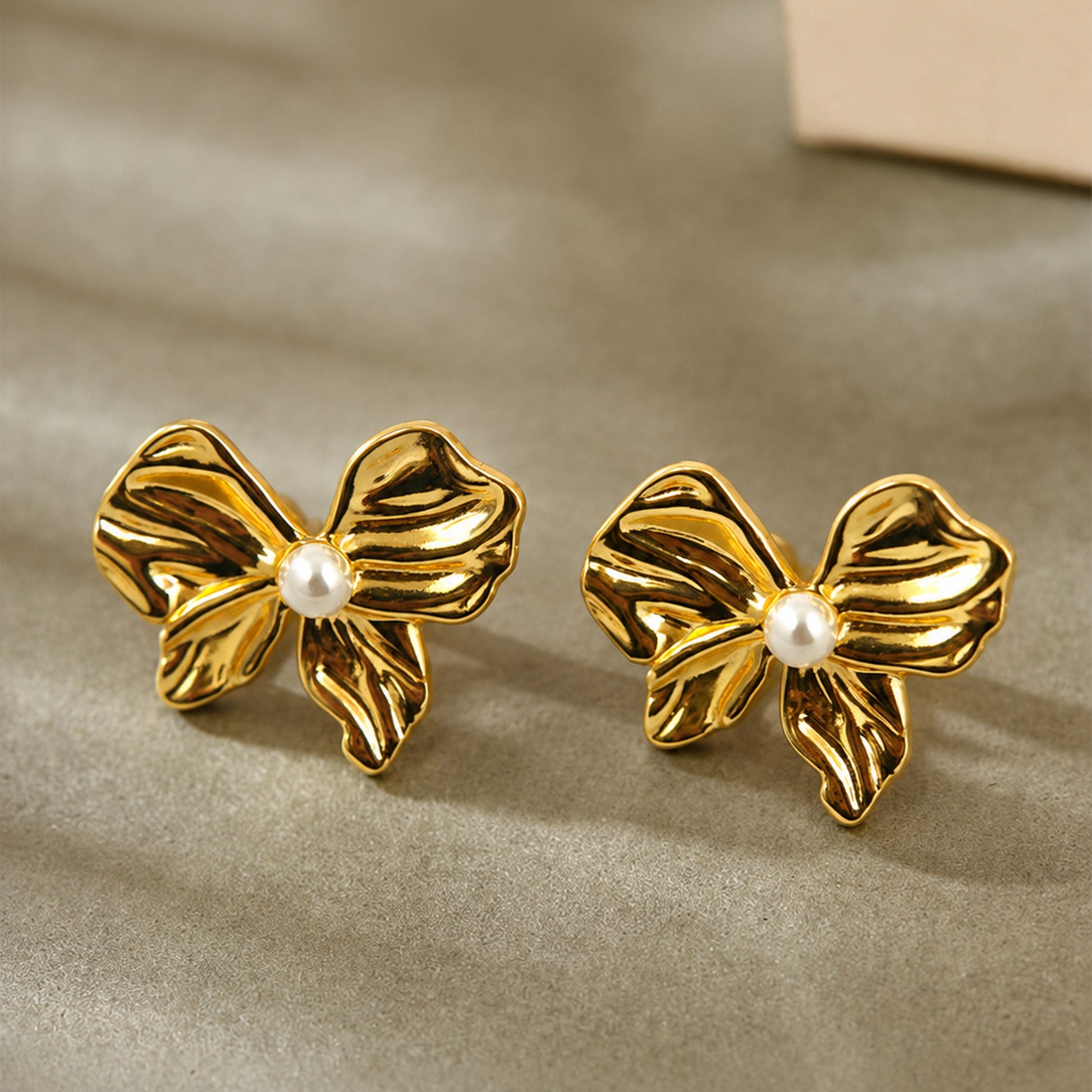 Gold plated bow stud earrings with textured detailing