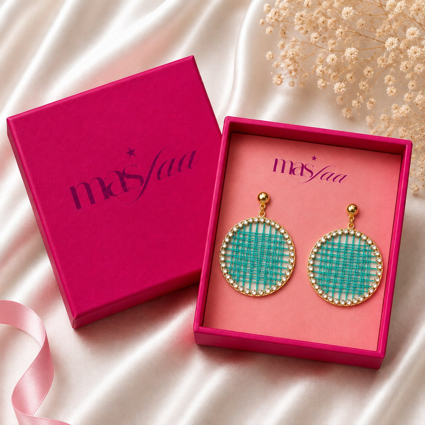 Detailed view of round drop earrings with sparkling stone border gift box
