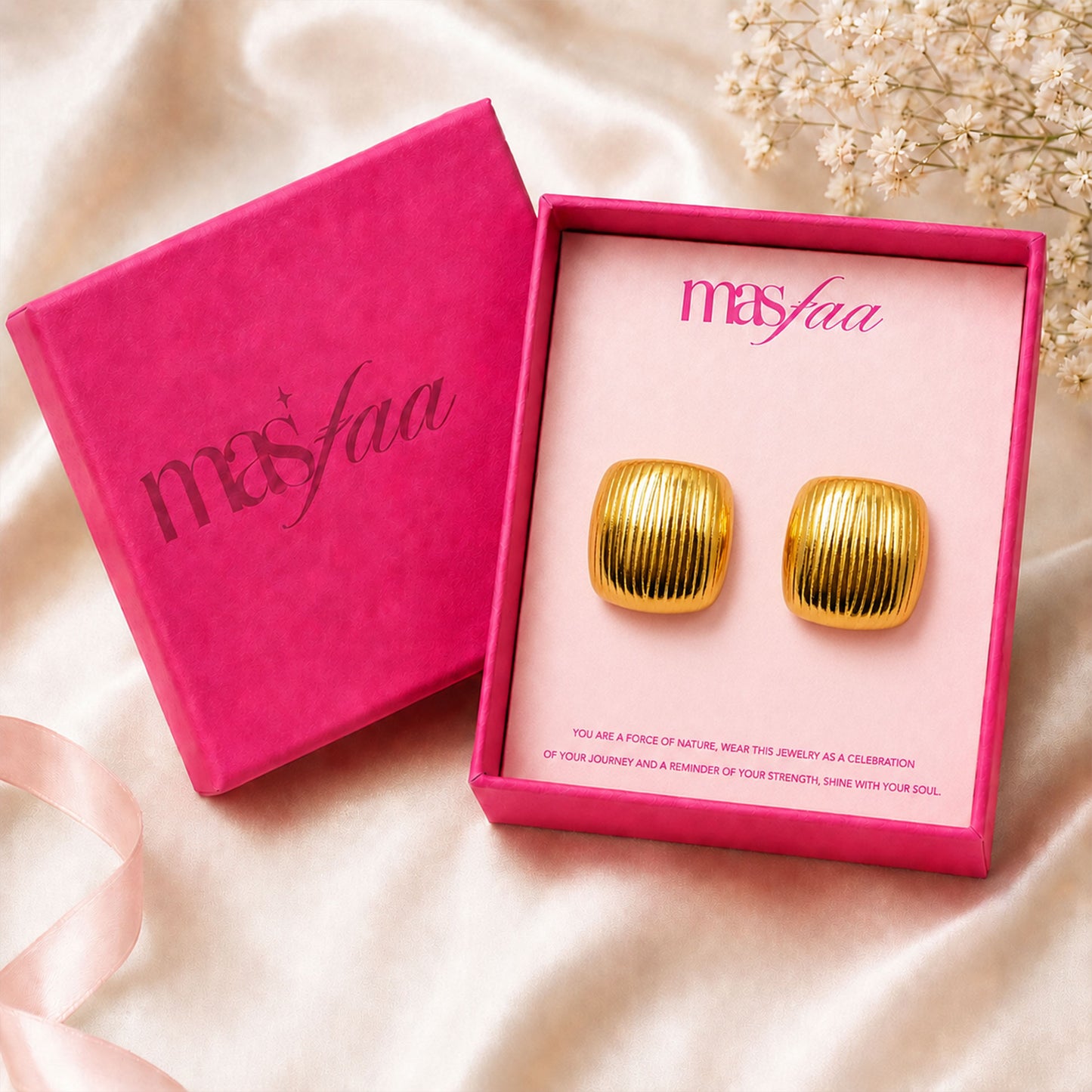 Detailed view of bold gold square dome stud earrings