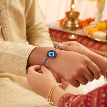 Multicolor braided thread rakhi with round evil eye design