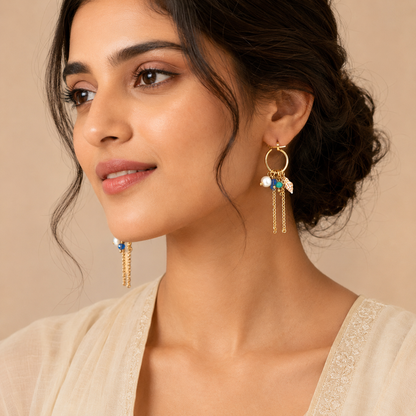 Close-up view of gold hoop earrings with pearl and shell charms