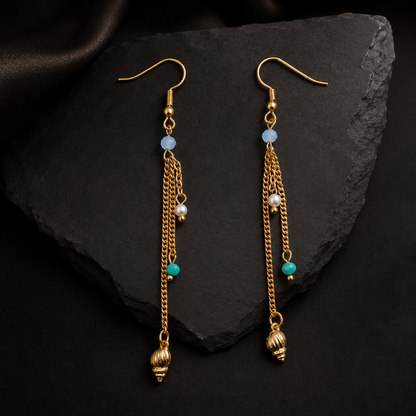 Detailed view of seashell charm earrings with chain tassels