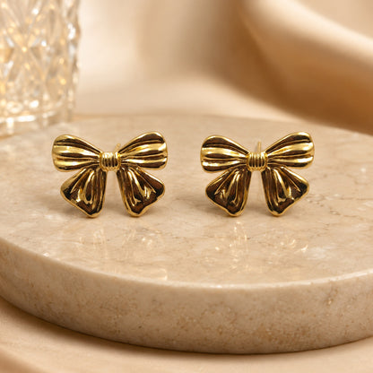Gold bow earrings styled as cute fashion jewellery for women