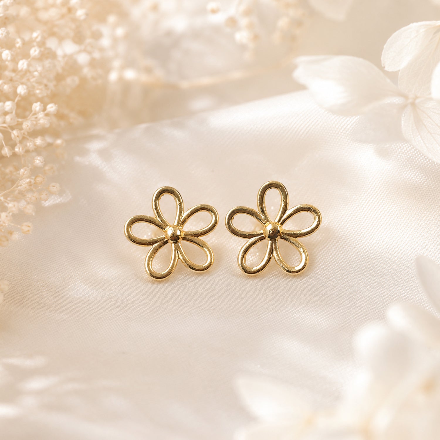 Detailed view of minimal gold outline floral stud earrings