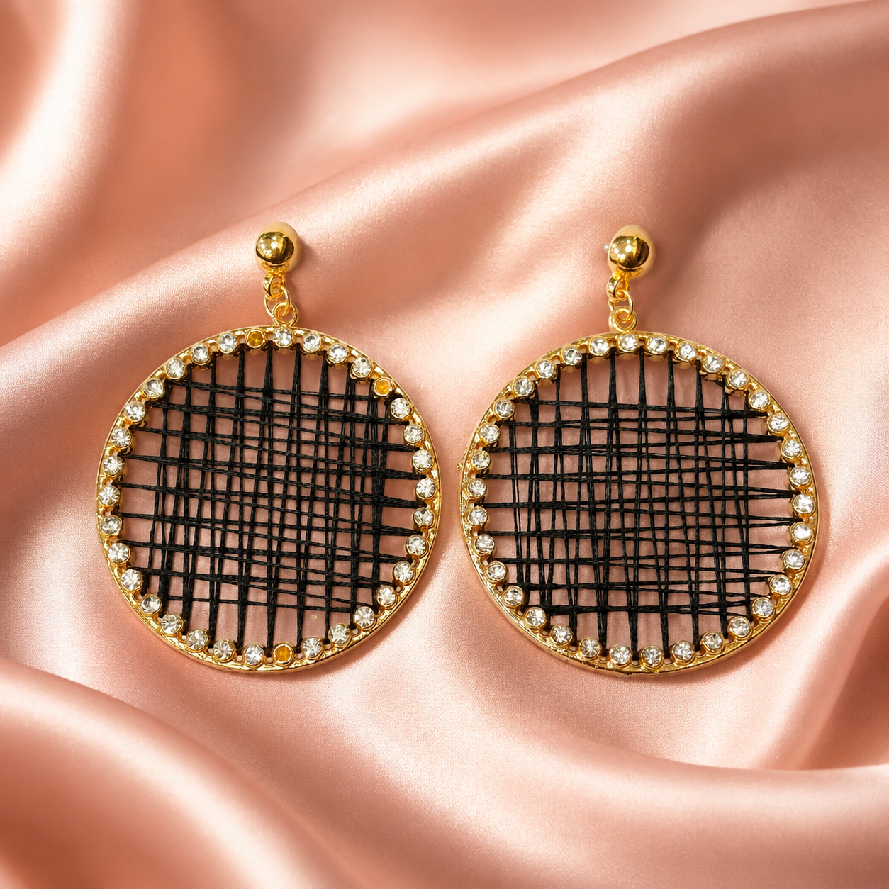 Detailed view of round drop earrings with sparkling stone border