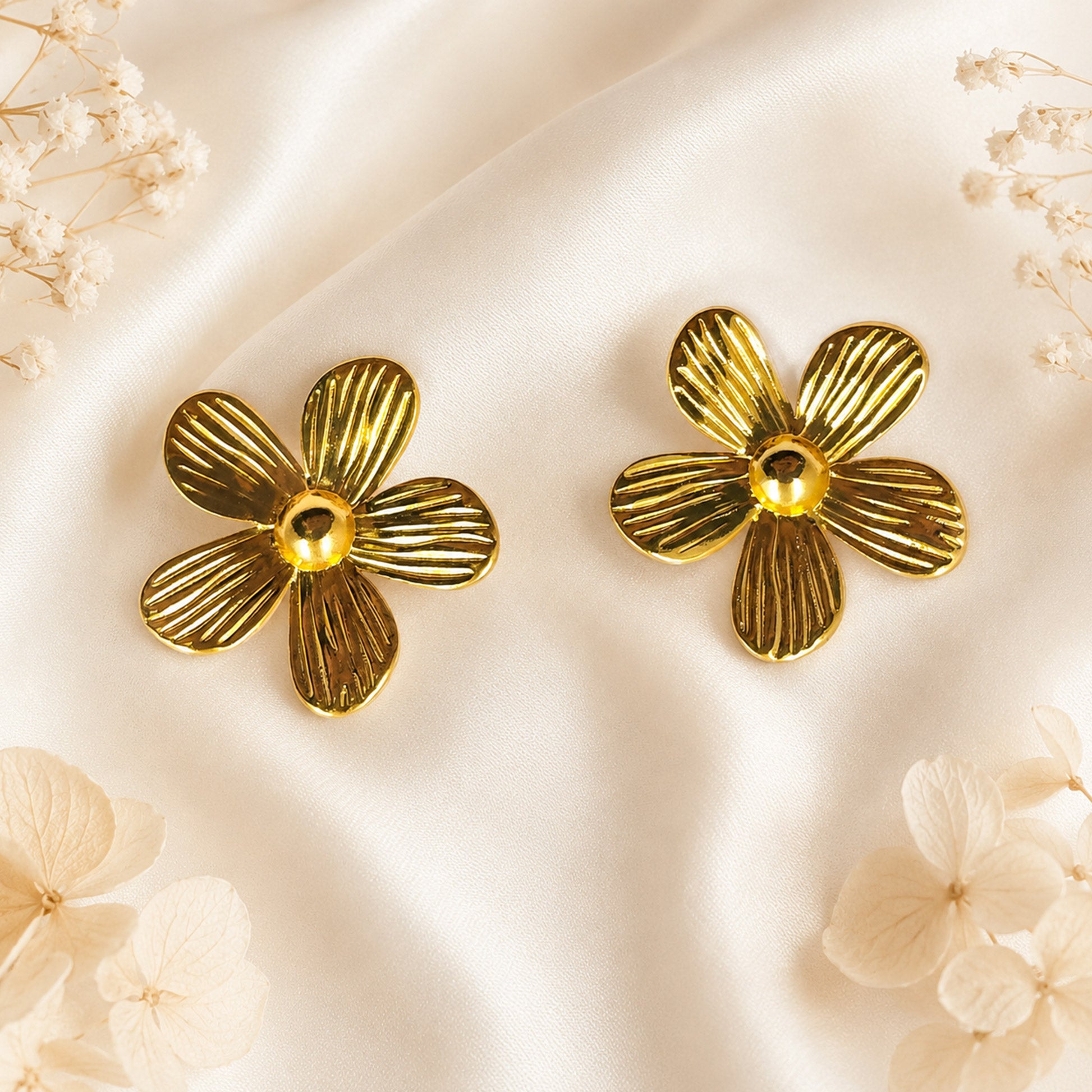 Close-up view of gold floral earrings with ribbed petal design