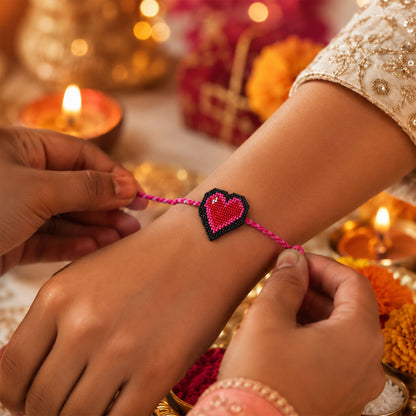 Pink braided thread rakhi with heart-shaped centerpiece