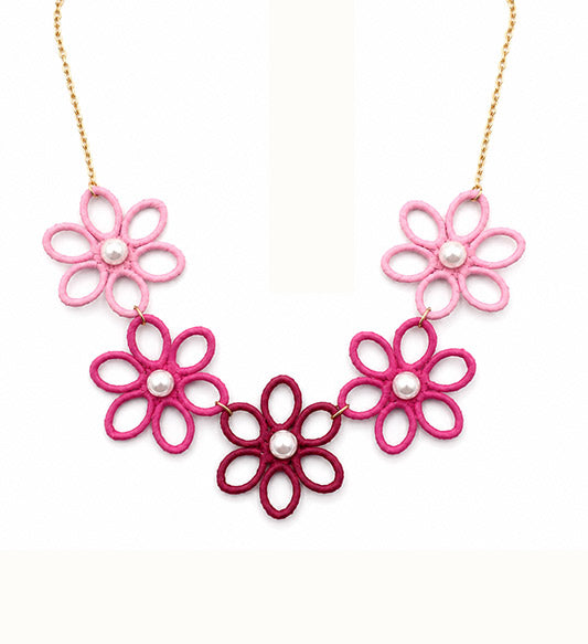 Pink floral pearl statement necklace on white background
