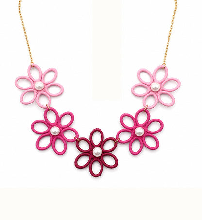 Pink floral pearl statement necklace on white background